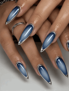 Blue chrome aura stiletto nails with silver metallic outline, glossy gradient nail design on long pointed nails