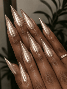 Champagne chrome stiletto nails with mirror metallic finish, luxury high-shine nail design on long pointed acrylic nails