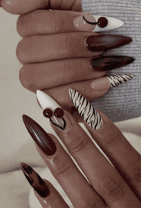 Burgundy ombre stiletto nails with cherry and zebra print accents, glossy mixed nail design on long nails
