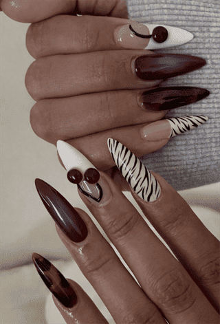 Burgundy ombre stiletto nails with cherry and zebra print accents, glossy mixed nail design on long nails