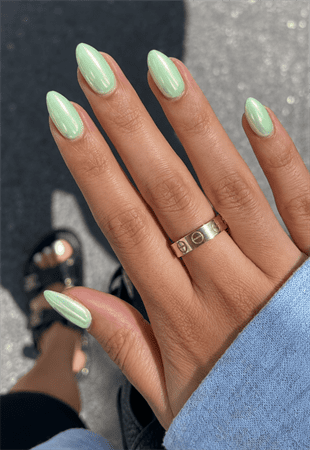 Glazed mint green almond nails with pearlescent chrome finish, glossy pastel nail design on medium-length almond nails