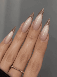Rose gold glitter French fade stiletto nails with nude pink base, elegant ombre glitter nail design on long pointed nails
