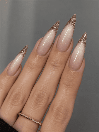 Rose gold glitter French fade stiletto nails with nude pink base, elegant ombre glitter nail design on long pointed nails