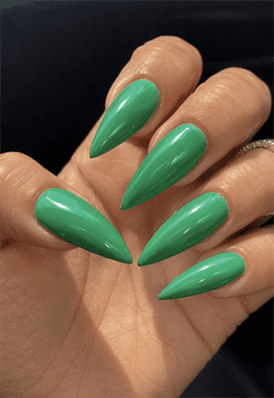 Glossy emerald green stiletto nails with solid color finish, sleek minimalist nail design on long pointed nails