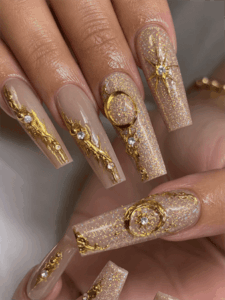 Gold celestial glitter coffin nails with 3D moon and star accents, luxury nude nail design with sparkling gold details
