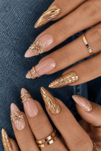 Gold sculpted floral stiletto nails with 3D metallic nail art, luxury nude pink manicure featuring gold chrome accents