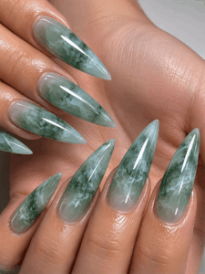 Jade marble stiletto nails with translucent green gemstone effect, glossy crystal-inspired nail design on long pointed nails