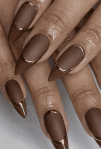 Matte chocolate brown French tip stiletto nails with gold chrome outline, nude base elegant nail design”