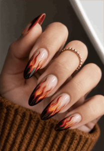 Molten flame almond nails with black smoky tips and fiery red orange flame nail art on nude base