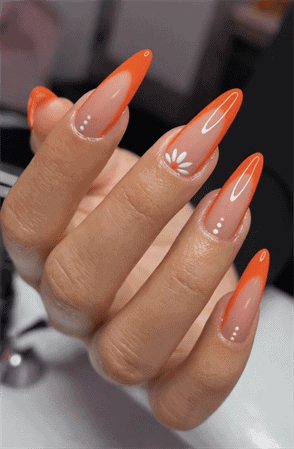 Neon orange French tip stiletto nails with daisy accent, glossy nude base bright floral nail design