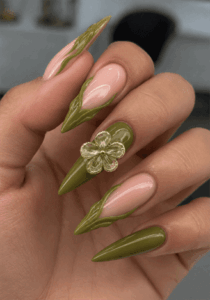 Olive green flame stiletto nails with 3D flower accent, glossy nude base nail design featuring botanical details