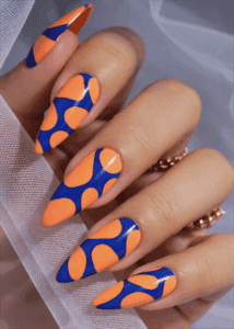 Orange and blue abstract stiletto nails with glossy finish, bold retro pattern nail design on long nails