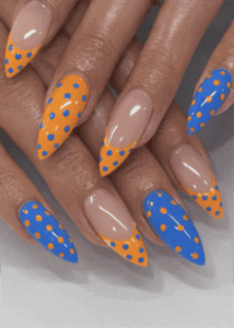 Orange and blue polka dot almond nails with glossy finish, colorful French tip nail design on nude base