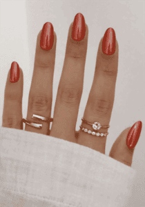 Orange chrome almond nails with metallic glossy finish, shimmering burnt orange nail design on long nails