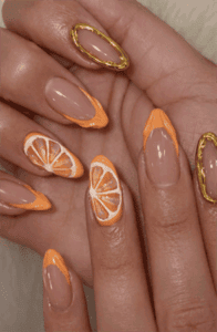Orange citrus French tip almond nails with 3D fruit slices, glossy nude base summer nail design