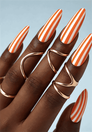 Orange and white striped stiletto nails with glossy finish, bold vertical stripe nail design on long nails