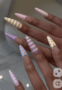 Pastel mix and match stiletto nails with stripes and polka dots, glossy nude base long nail design