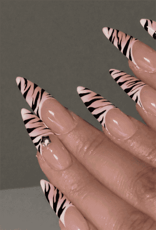 Pink zebra print French tip stiletto nails with glossy finish, nude base animal print nail design