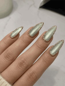 Sage green cat eye chrome almond nails with gold outline accents, glossy metallic nail design featuring magnetic shimmer effect