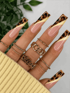 Tortoiseshell French tip coffin nails with nude pink base and cream swirl accents, glossy luxury nail design