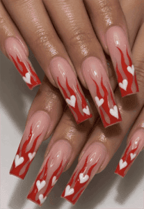 Valentine flame coffin nails with red flame tips and white heart accents, glossy nude base nail design