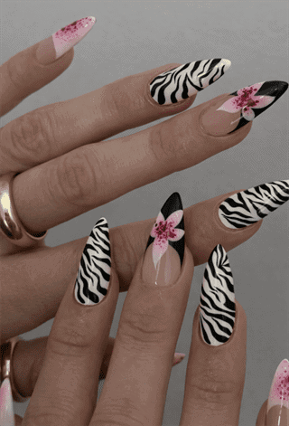 Zebra print almond nails with pink floral accents and black French tips, glossy animal print nail design