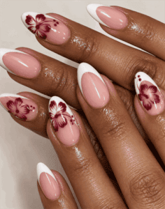 Burgundy hibiscus French tip almond nails with white tips, hand-painted floral nail art and glossy nude pink base