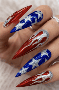 Glitter patriotic flame stiletto nails with red chrome flames, blue star nail art and silver glitter accents, glossy Fourth of July manicure
