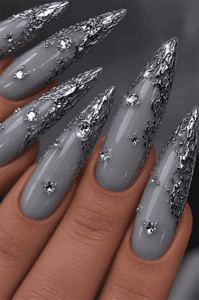 Gunmetal foil stiletto nails with silver chrome textured tips, gray glossy base, crystal rhinestones and luxury metallic nail art
