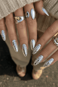 Mirror chrome almond nails with silver mosaic accent nails, reflective metallic finish and luxury futuristic nail design