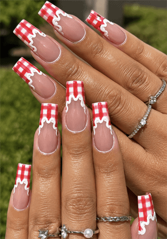 Red gingham French tip coffin nails with white drip accents, glossy picnic-inspired nail design on nude pink base