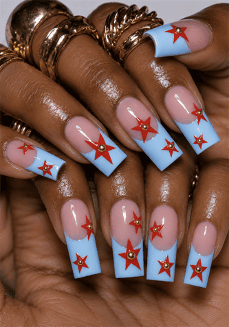 Baby blue French tip coffin nails with red star accents, glossy retro Americana nail design featuring gold stud embellishments