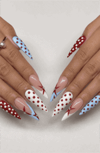 Red, white and blue polka dot stiletto nails with abstract French tips, patriotic nail design featuring geometric accents and glossy finish