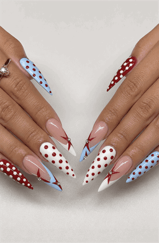 Red, white and blue polka dot stiletto nails with abstract French tips, patriotic nail design featuring geometric accents and glossy finish