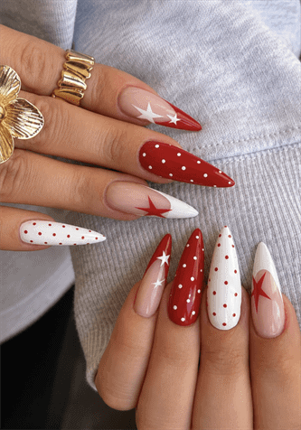 Red and white star stiletto nails with polka dot accents, glossy patriotic nail design on a nude base featuring bold Americana-inspired nail art