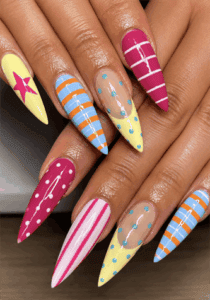 Retro pop art stiletto nails with colorful geometric patterns, stripes, polka dots and star nail art on long pointed nails