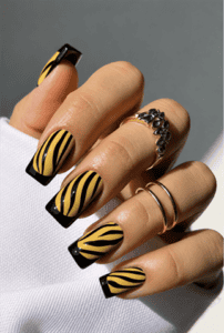 Yellow and black zebra French tip coffin nails with glossy finish, animal print nail art and bold safari-inspired manicure