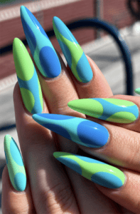 Blue and lime green abstract stiletto nails with glossy color block nail art, retro geometric design and vibrant summer manicure