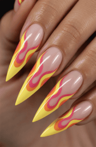 Neon yellow flame French tip stiletto nails with pink and orange retro swirl nail art, glossy nude base and bold Y2K-inspired manicure