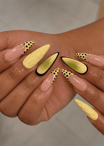 Butter yellow almond nails with black polka dot French tips, abstract aura accents and 3D textured nail art on a glossy nude base