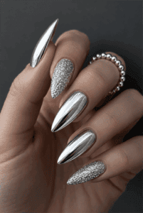 Silver chrome almond nails with textured silver glitter accent nails, mirror metallic finish and luxury monochrome manicure