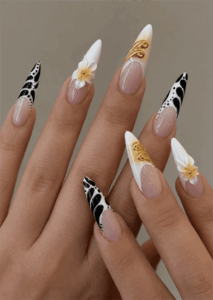 Black, white and gold luxury stiletto nails with abstract French tips, 3D floral accents and metallic embellishments on a glossy nude base
