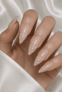 Pearl French tip stiletto nails with 3D pearl embellishments, glossy nude base and elegant bridal nail design