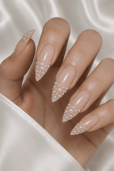 Pearl French tip stiletto nails with 3D pearl embellishments, glossy nude base and elegant bridal nail design