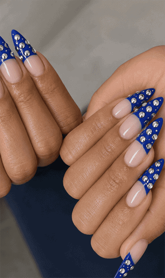 Royal blue rhinestone French tip stiletto nails with silver crystal embellishments, glossy nude base and luxury statement manicure