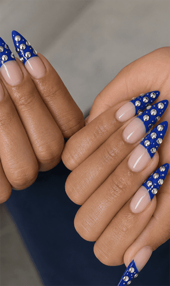 Royal blue rhinestone French tip stiletto nails with silver crystal embellishments, glossy nude base and luxury statement manicure