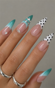 Teal ombré and black polka dot French tip stiletto nails with rhinestone accents, glossy nude base and modern statement manicure