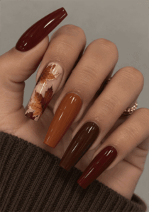 Autumn leaf coffin nails with burgundy, burnt orange and chocolate brown polish, maple leaf accent art and glossy fall finish