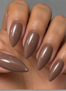 Long almond nails with glossy light brown polish and a warm mocha-taupe finish