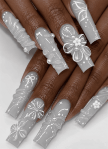 Gray coffin nails with white 3D floral nail art, pearl embellishments and delicate bow details